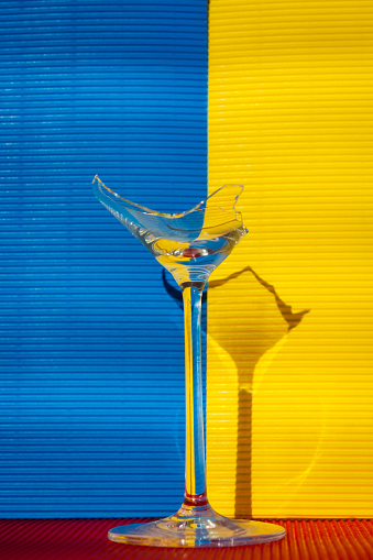 Broken wine glass against colorful background