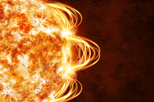 An intense and detailed image of the sun's surface with a solar flare arcing over the horizon, displaying the power of magnetic solar energy.
