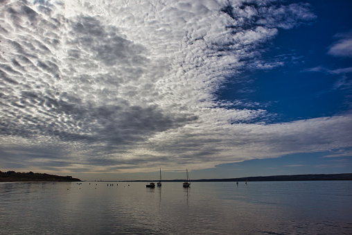 Small boats under big sky with featured clouds