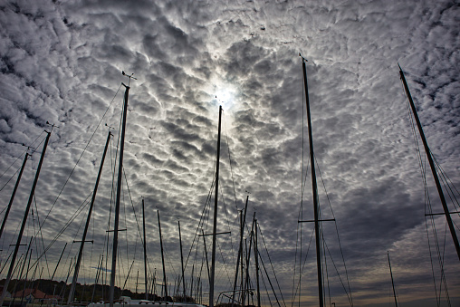 Dramatic sky over silhouettes of sailing boat masts