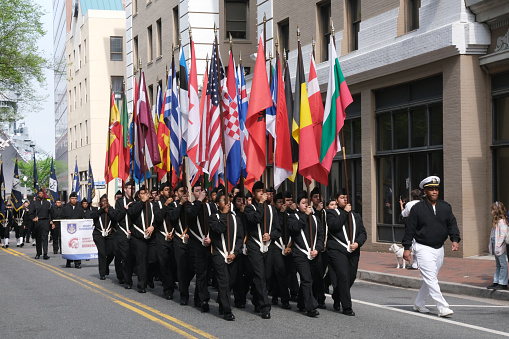 Norfolk, Virginia, USA: April 20th 2024:  During the 75th anniversary of the NATO Parade in Norfolk, Virginia the military cadets carry the parade of nations flags along the  Norfolk city parade route.