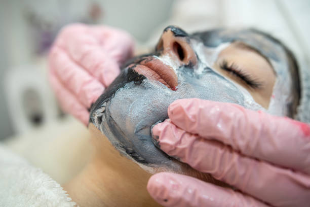 istock hands of a cosmetologist massage a face on which a mask is applied 2149784649