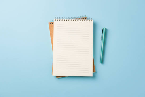 istock Top view of notebook and fountain pen on blue background 2149784713
