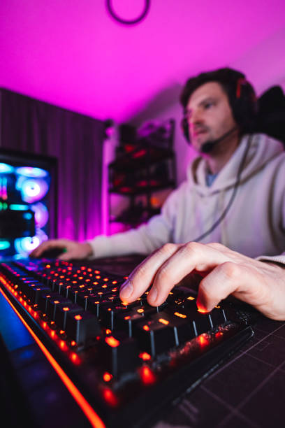 istock Gamer playing games in his dark office with mood lightning at night 2149785635