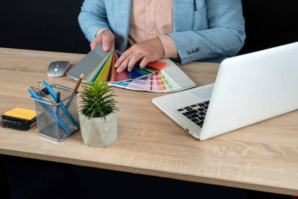 istock male graphic designer choice color swatch, use laptop, notepad and pen 2149785675