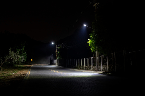 empty road at night with street lights. lanterns illuminate the road