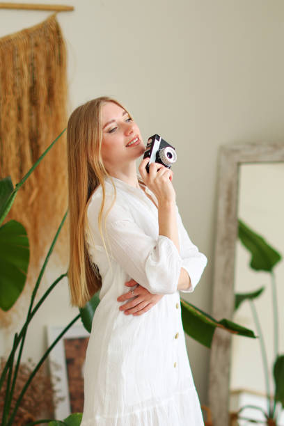 istock girl with a camera surrounded by home plants 2149785792