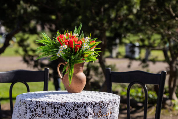 Flower pot on a table with lace tablecloth outdoors