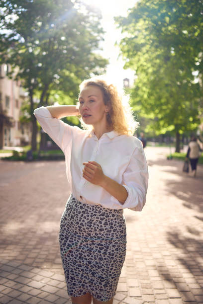 istock a beautiful middle age woman in 70s, 80s style clothes stretches after work on a sun drenched alley 2149786614
