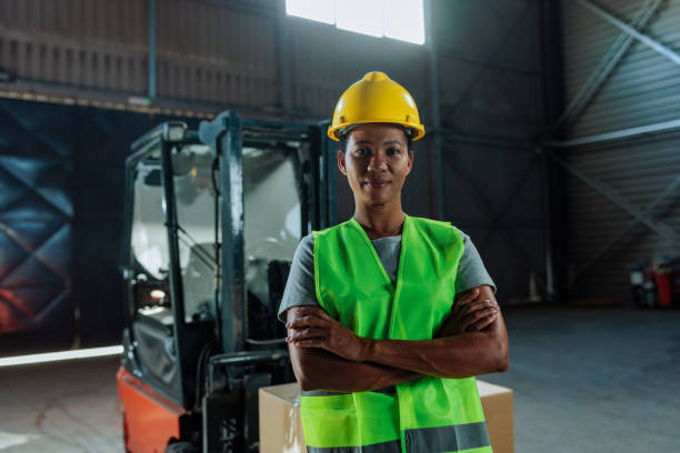 istock Customs warehouse female worker posing and smiling with her yellow hardhat on 2149786939
