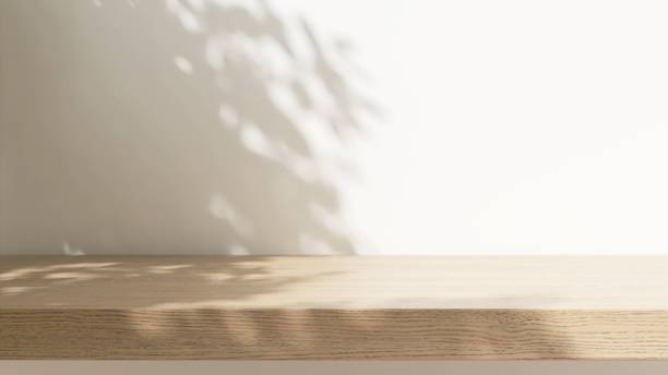 istock Minimal empty wooden countertop counter in sunlight, leaf foliage shadow on white wall 2149787024