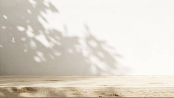 istock Minimal empty wooden countertop counter in sunlight, leaf foliage shadow on white wall 2149787035