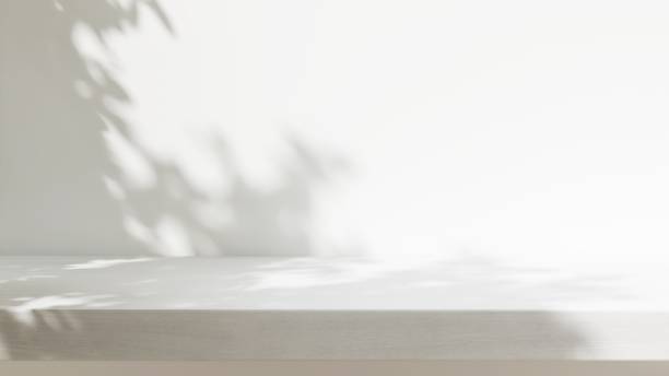 istock Minimal empty white wooden countertop counter in sunlight, leaf foliage shadow on white wall 2149787342