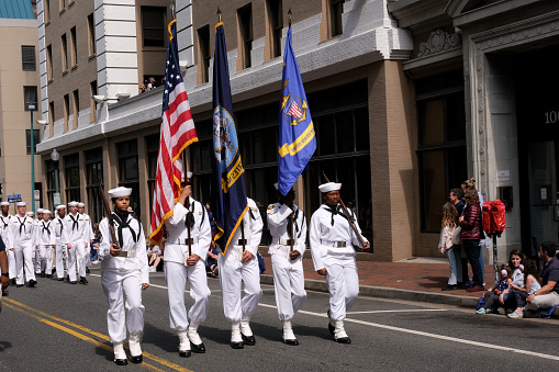 Norfolk, Virginia, USA: April 20th 2024:  During the 75th anniversary of the NATO Parade in Norfolk, Virginia the military cadets carry the parade of nations flags along the  Norfolk city parade route.