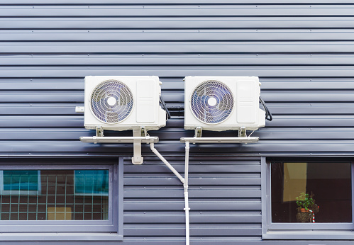 Two External air conditioners unit on business building wall.