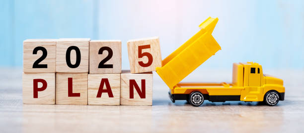 istock 2025 Plan cube blocks with miniature truck or construction vehicle. New Start, Vision, Resolution, goal, industrial, Warehouse and happy New Year concept 2149791679