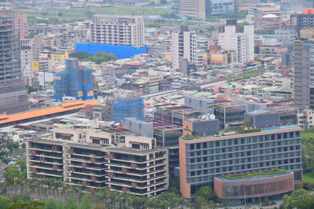 Taiwan - Apr 05, 2024: On a hazy, overcast day, a panoramic view of Shilin District unfolds from Jiantan Shan (劍潭山) in Taipei City. Amidst the towering skyscrapers, construction continues on numerous others.