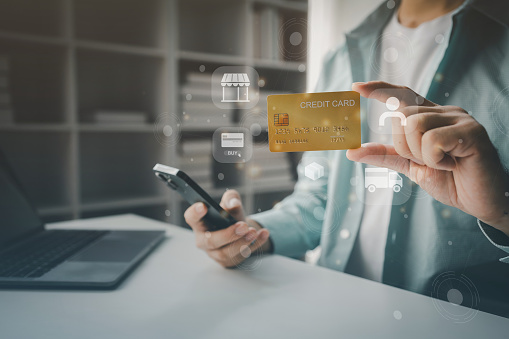 Online shopping and credit card payment concept, person is shopping on an online shopping website, purchasing goods and services securely, debiting credit card to pay for goods on the internet.