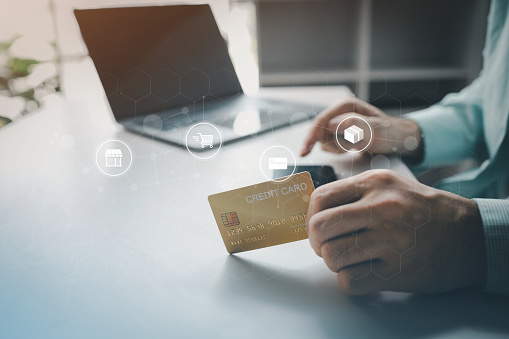 Online shopping and credit card payment concept, person is shopping on an online shopping website, purchasing goods and services securely, debiting credit card to pay for goods on the internet.
