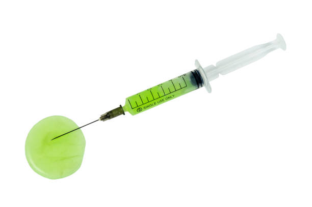A syringe with a green liquid in it is on a white background A syringe with a green liquid in it is on a white background. pre-exposure-prophylaxis stock pictures, royalty-free photos & images