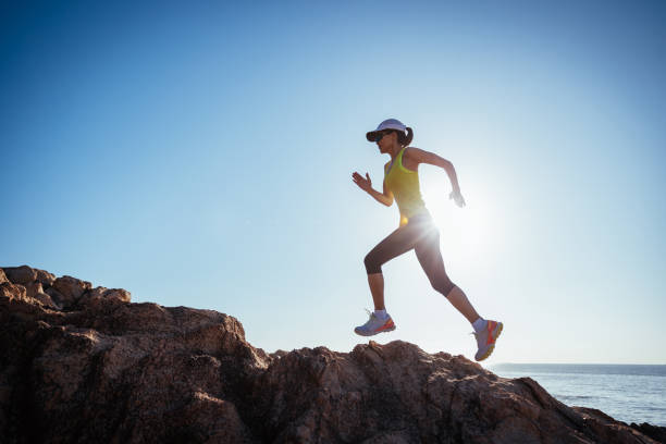 istock Woman runner running on sunrise seaside rocks 2149794722