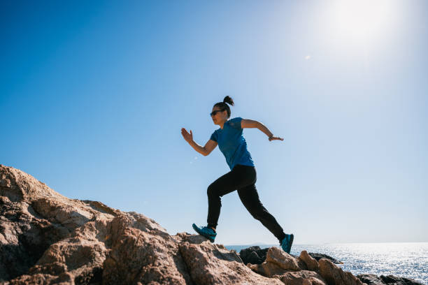 istock Woman runner running on sunrise seaside rocky mountains 2149794852