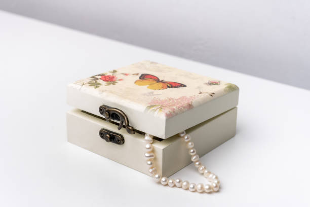 Pearls in a open trinket box isolated on white background.