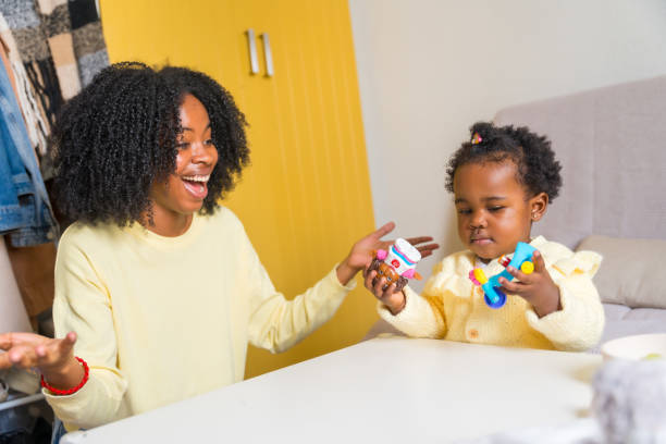 istock African girl learning while playing with her mother at home 2149798405