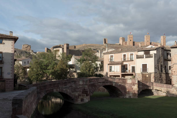 istock a historic town with stone buildings, an arched bridge, and distant castles under a partly cloudy sky 2149799759