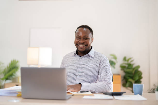 istock African American businessman working with laptop Take notes on documents in the office and prepare performance analysis reports. 2149799914