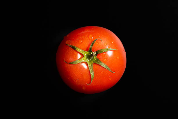 istock Fresh tomato isolated against black background. Organic tomato, top view 2149800050
