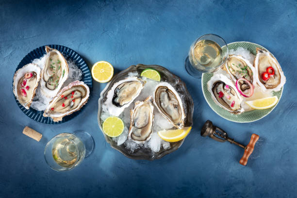 istock Oysters on ice, with various toppings and white wine, overhead flat lay shot 2149802367