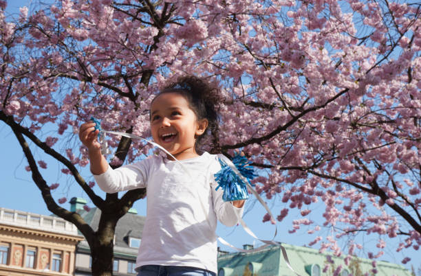Portrait of a girl standing in park with cherry trees during spring
