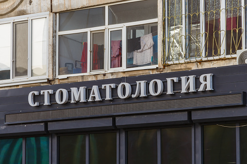 Uralsk, Oral, Kazakhstan (Qazaqstan), 22.04.2024 - Signboard with three-dimensional letters Dentistry on a residential building.