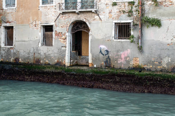 A Banksy street art piece painted on the walls of an abandoned Venetian palace; Venice Venice, Veneto, Italy - Jan 23rd, 2024: A Banksy street art piece painted on the walls of an abandoned Venetian palace banksy stock pictures, royalty-free photos & images