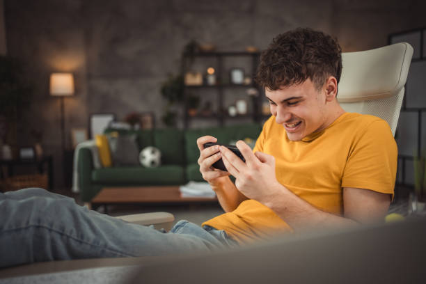 istock A teenager takes a break from studying, having fun using a mobile phone for video games or surfing the Internet while sitting at a desk 2149803663