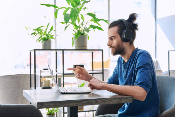 istock Young handsome man in headphones having work video chat using laptop 2149804720