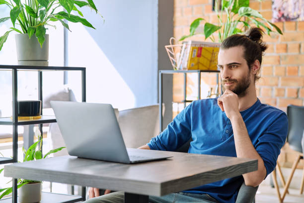 istock Young serious man working, studying using laptop sitting in coworking cafe 2149804772