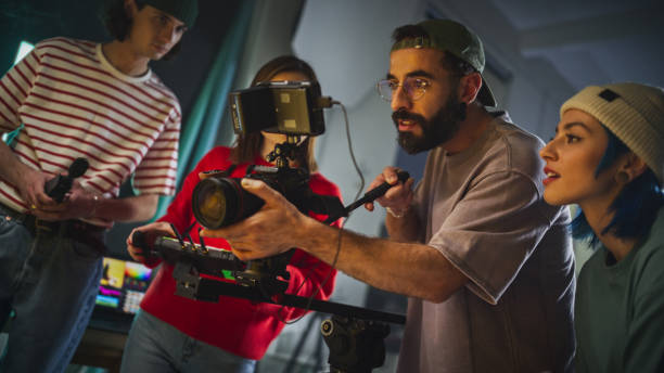 istock Dynamic Young Team Engaged In Video Production On A Film Set, Featuring Diverse Cinematographers With Camera Equipment, Focused On Creating Compelling Visual Content In A Studio Environment. 2149805548