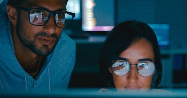 istock Closeup of Tech team professionals collaborate discuss software development strategies late night in modern office. Software developer, artificial intelligence and programming. 2149809210