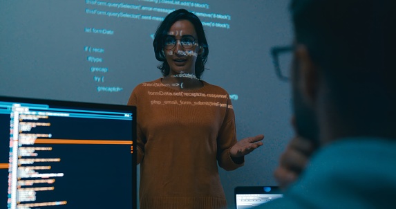 Female programmer is giving an interactive training session, focusing on hands-on learning in digital classroom environment. Software developer, artificial intelligence and programming concept.