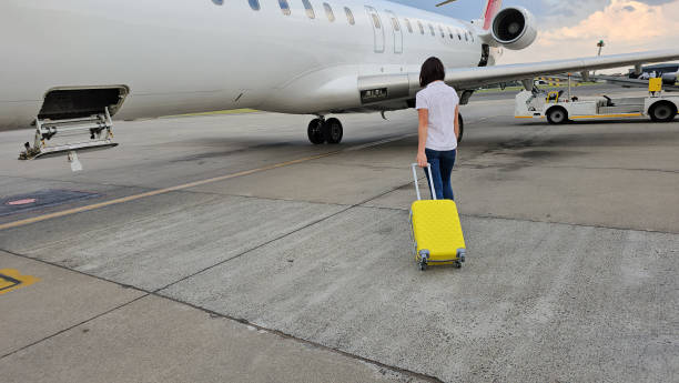 istock Man Walking Towards Airplane With Yellow Suitcase 2149809947
