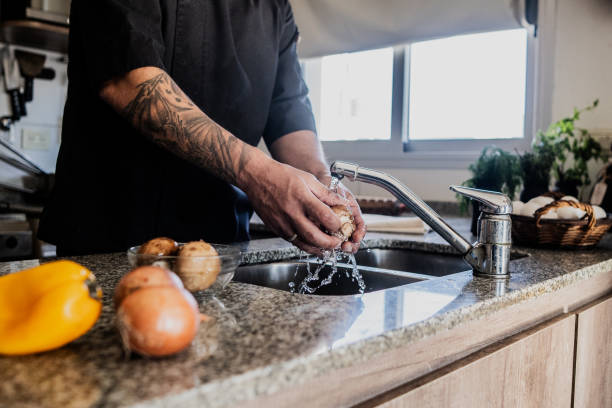 Man washing champignon in the sink at home