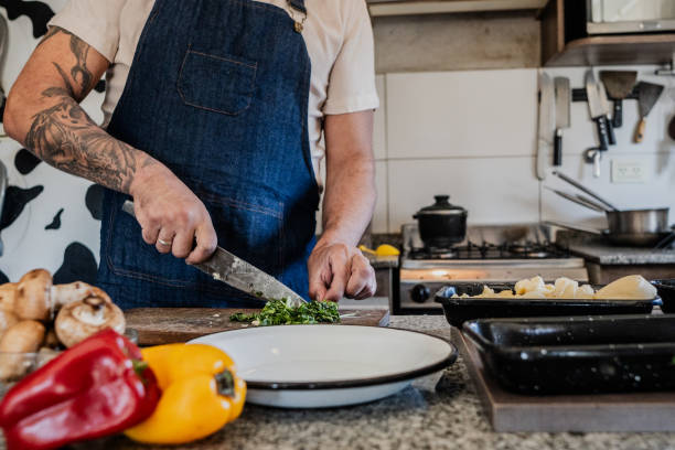 istock Close-up of a man cutting arugula on cutting board in kitchen 2149809993