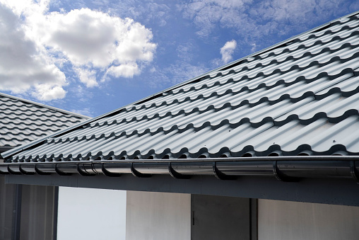Corrugated metal roof tile and gutter on sky bacground