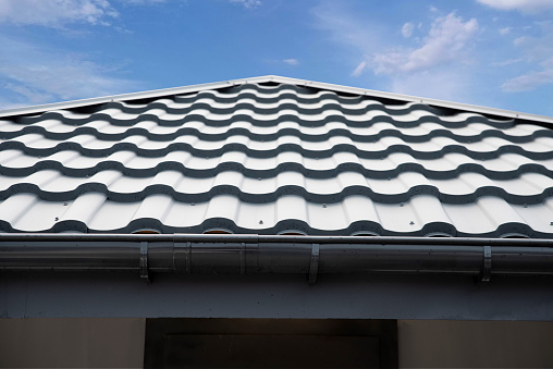 Corrugated metal roof tile and gutter on sky bacground