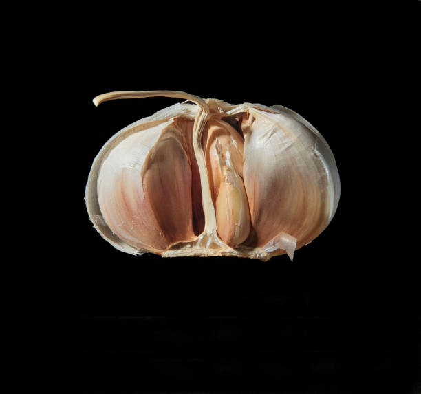 istock Half a garlic bulb with cloves on black background with copy space 2149810726