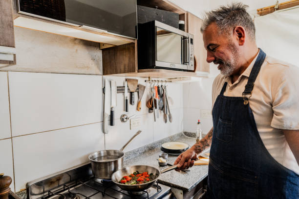 istock Mature man cooking at home 2149810847