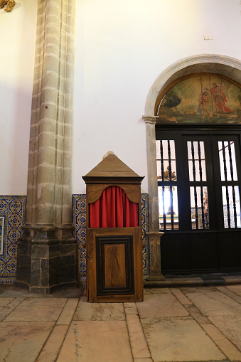 Elvas,Portugal- October 14, 2023: Old wooden confessionals with red curtain in Our Lady of Assumption Cathedral in Elvas