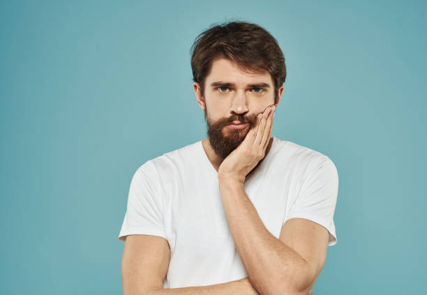 istock guy in a white t-shirt on a blue background sad look model Copy Space 2149810970